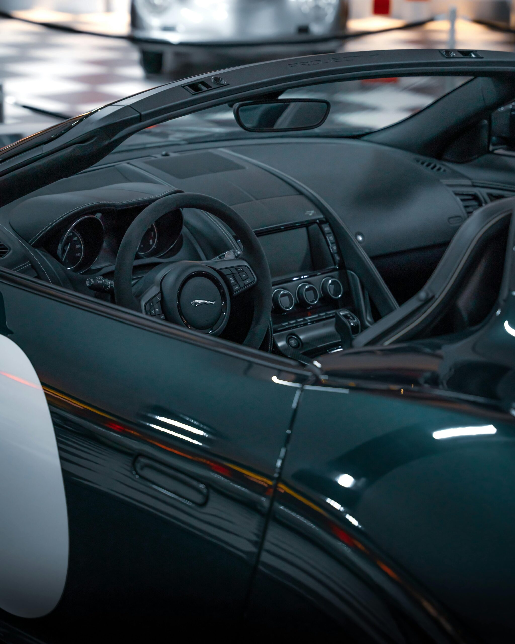 Detailed view of a classic Jaguar convertible with luxurious interior in a showroom setting.